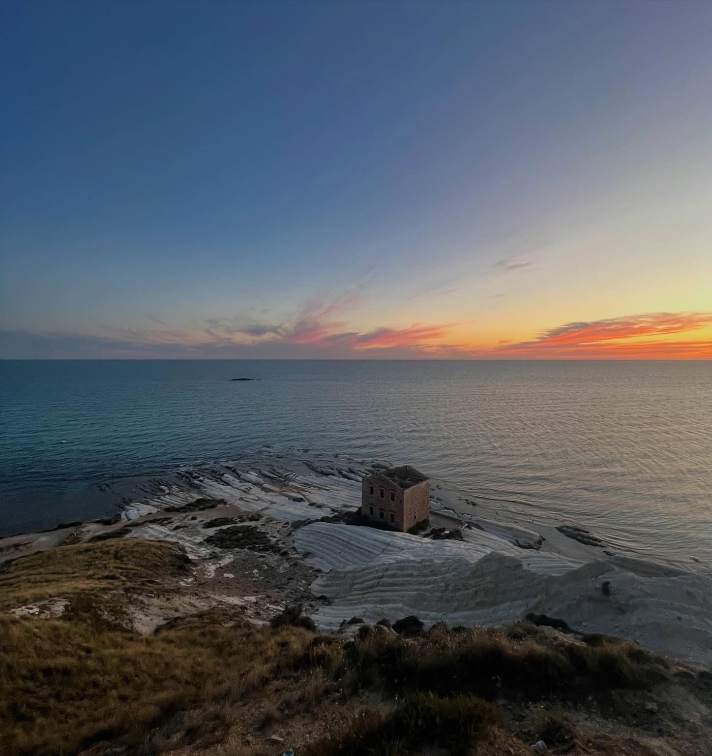 La scogliera bianca di Punta Bianca sul mare al tramonto